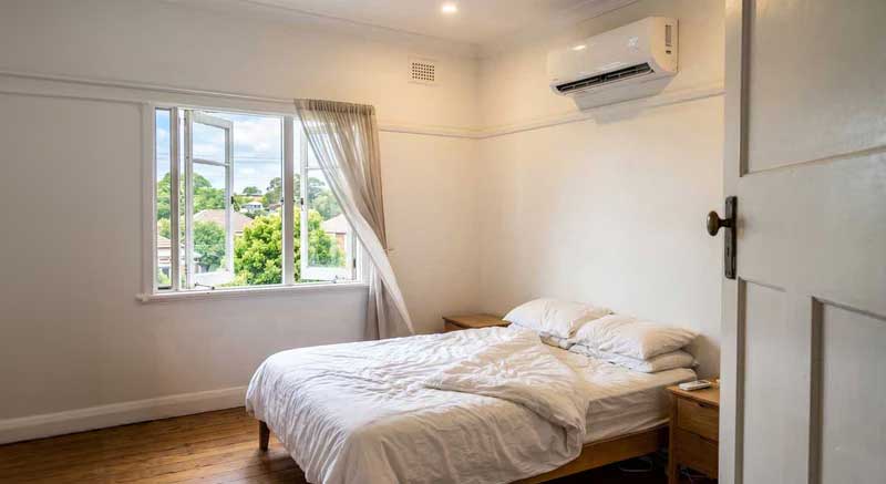 AC running on the wall while the balcony door is left open